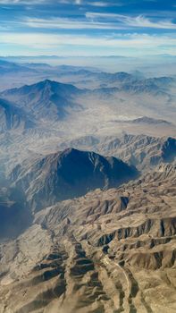 Stunning aerial view of Kabul's mountainous terrain showcasing rugged landscapes under a clear blue sky.