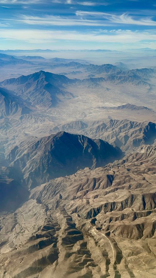 Free Stunning aerial view of Kabul's mountainous terrain showcasing rugged landscapes under a clear blue sky. Stock Photo