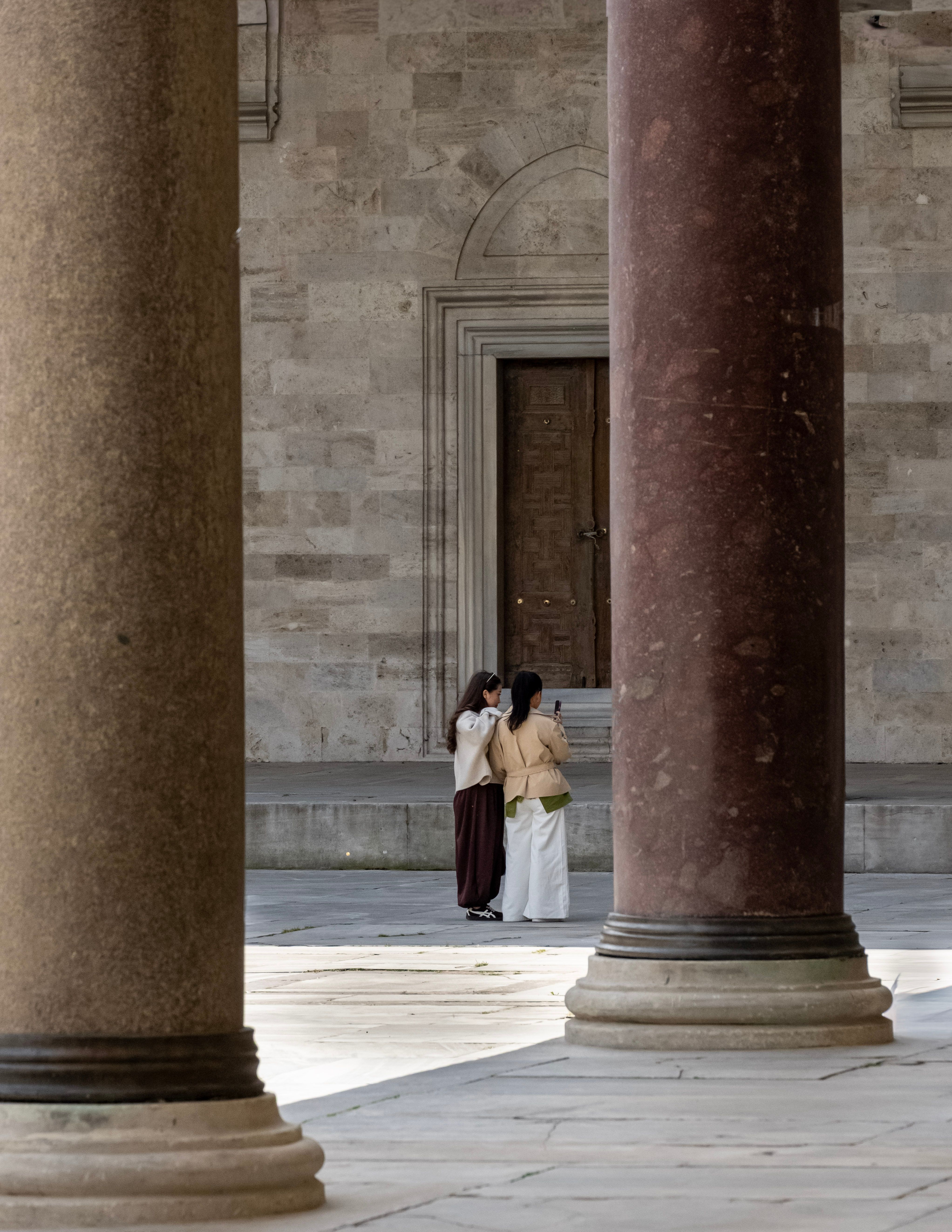 Two People Observing Historical Architecture · Free Stock Photo