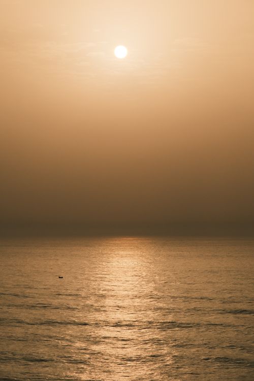 Free Golden sunset over a tranquil ocean, creating a serene and peaceful atmosphere. Stock Photo