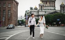 新娘和新郎快乐地在俄罗斯圣以撒大教堂附近散步
