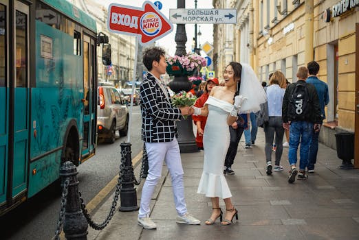 一对迷人的亚洲夫妇身着婚纱，在俄罗斯充满活力的街道上快乐地漫步