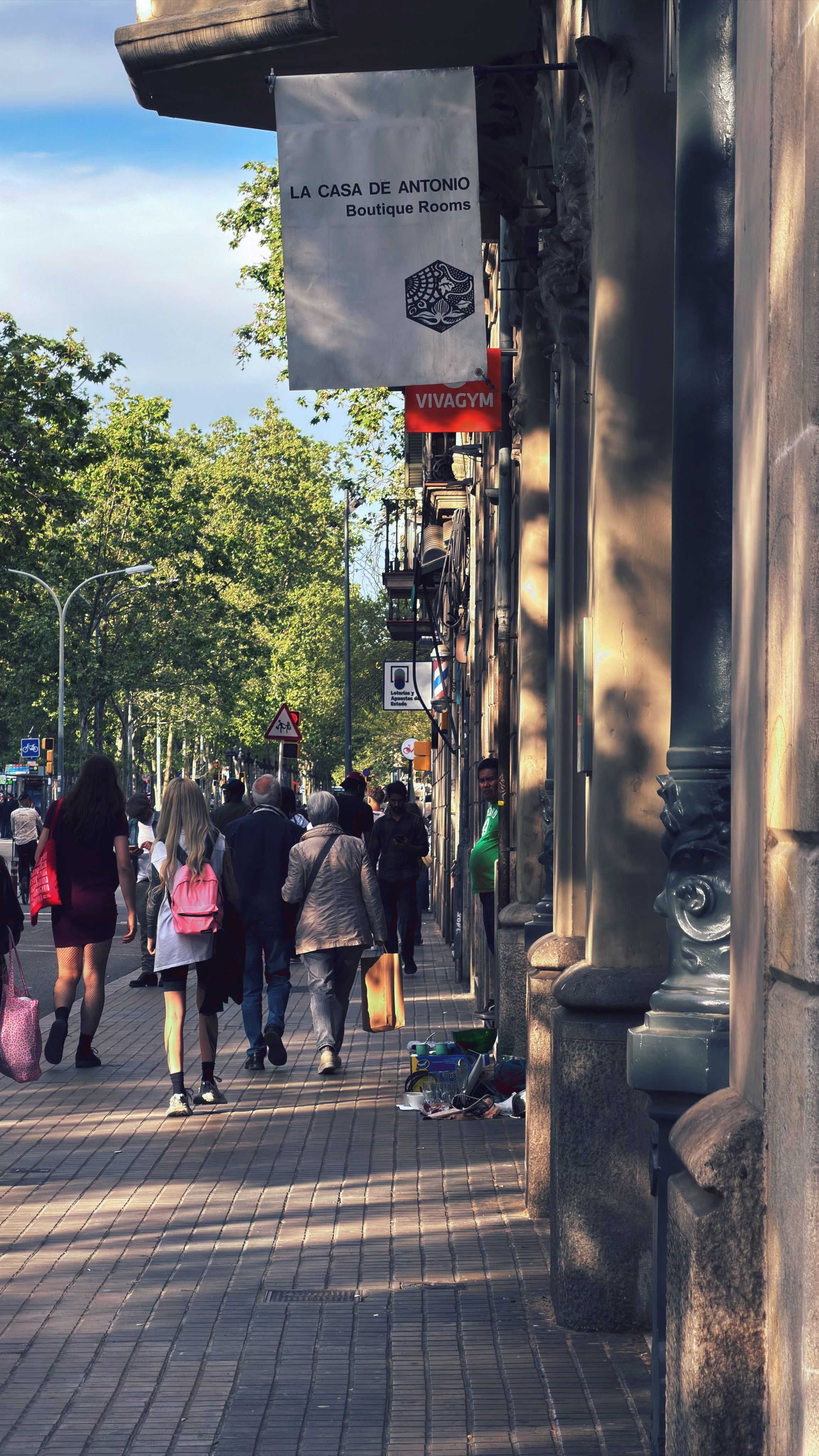 Urban street scene in Barcelona capturing daily life with pedestrians and boutique shops.