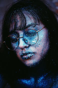 一位化着闪光妆、戴着眼镜的女性特写，捕捉到了艺术表达