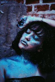 一位年轻女子的迷人肖像，脸上和肩头闪烁着艺术感的蓝色光芒