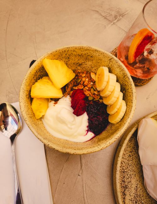 Free Tasty fruit and yogurt bowl topped with granola, perfect for healthy breakfast enthusiasts. Stock Photo