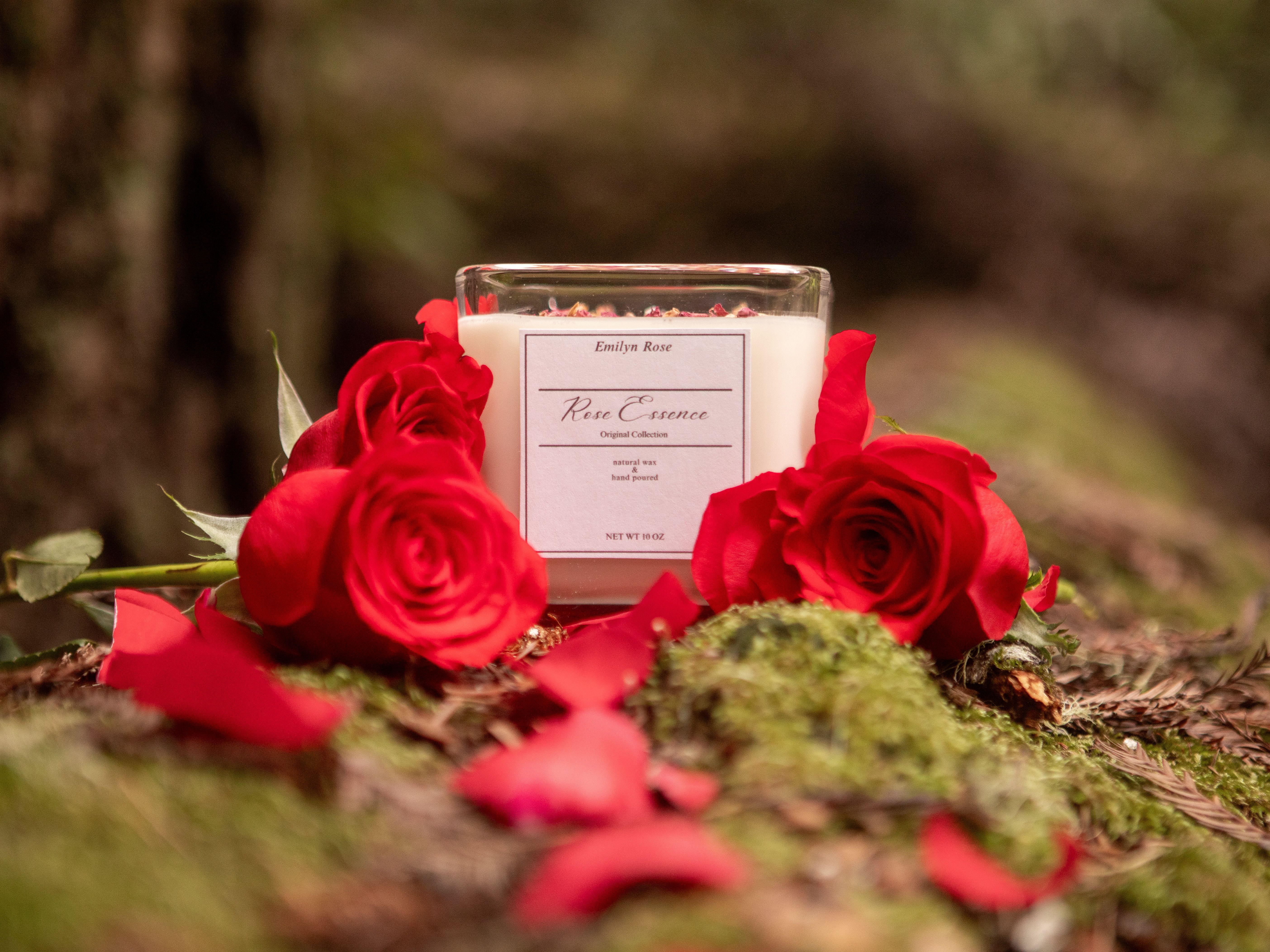 Elegant candle with rose petals nestled among red roses, creating a romantic scene.
