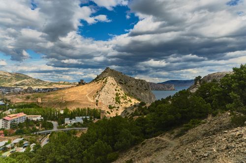 Free Stunning landscape of Crimean mountains with sea and town under a dramatic sky. Stock Photo