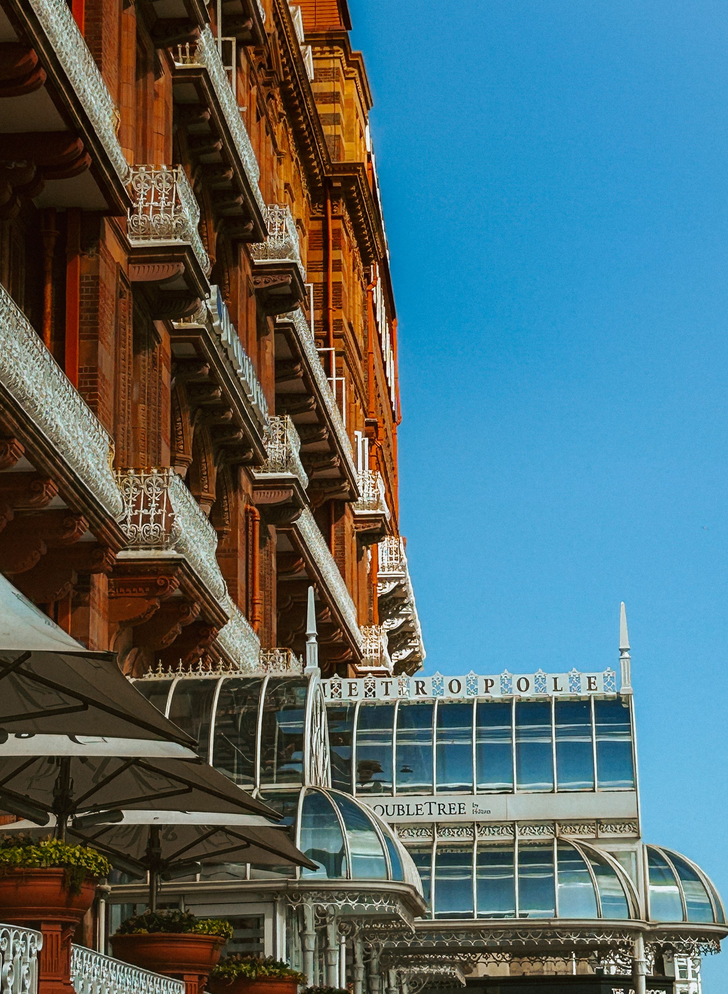 A blend of Victorian architecture with modern glass elements under a clear blue sky.