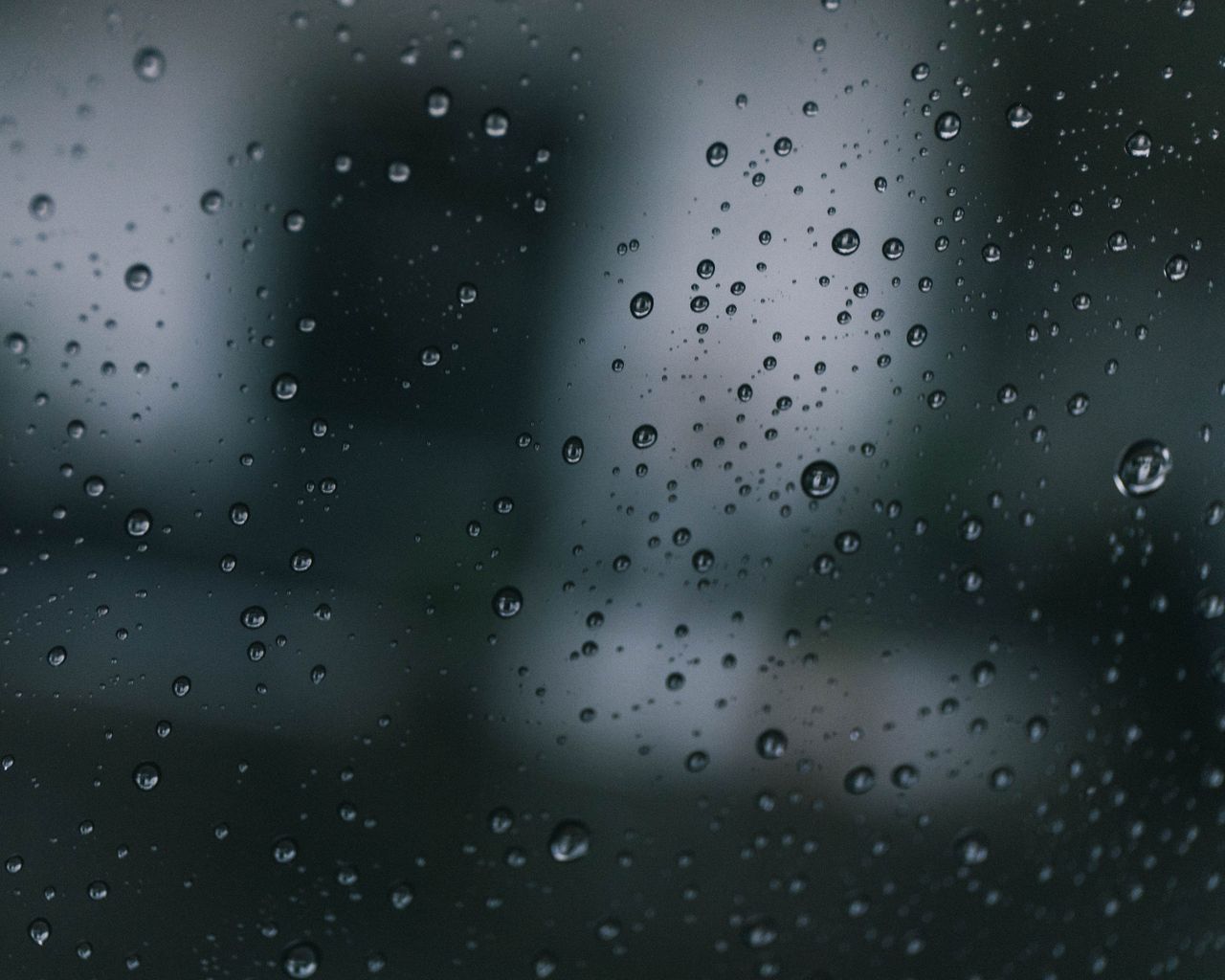 detailed macro photo capturing water droplets on glass with a moody ba