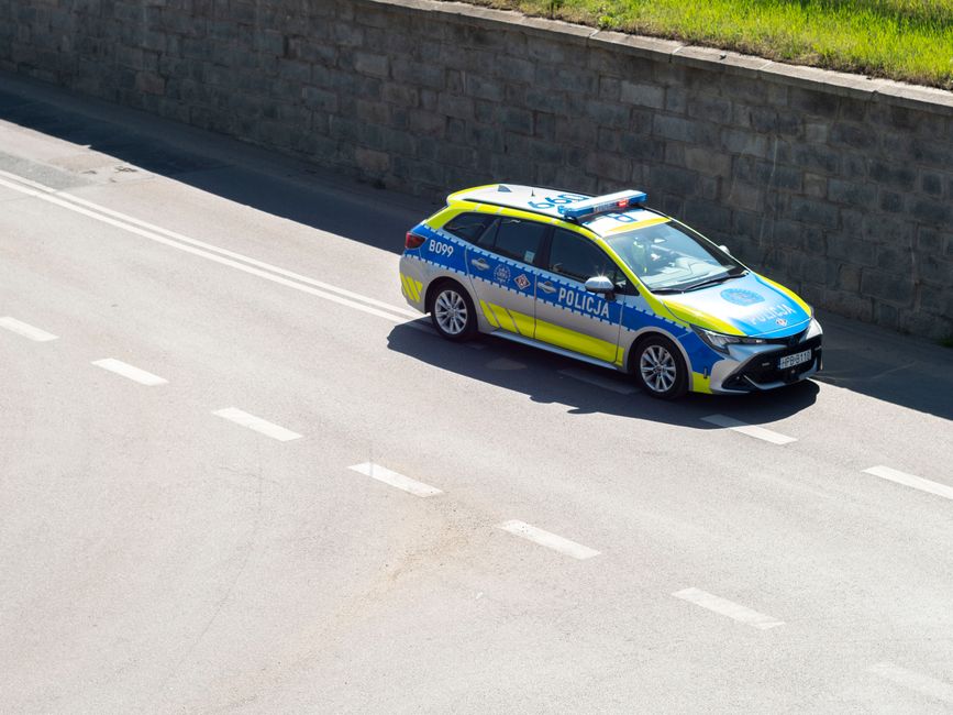 A Polish police car driving along a street in Wrocław, Poland, captured from an elevated angle.
