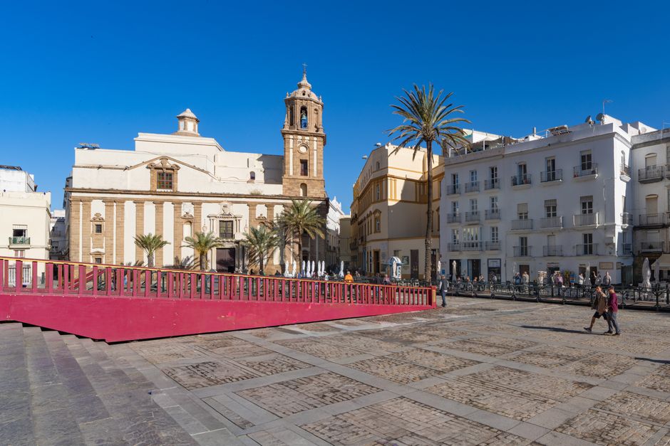 Vista panorámica de una plaza histórica en Cádiz, España, que muestra su hermosa arquitectura y la vibrante vida callejera bajo un cielo…