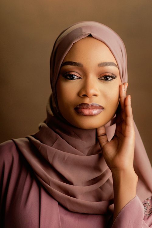 Free Portrait of a woman wearing a hijab, showcasing elegance and grace with soft lighting and warm tones. Stock Photo