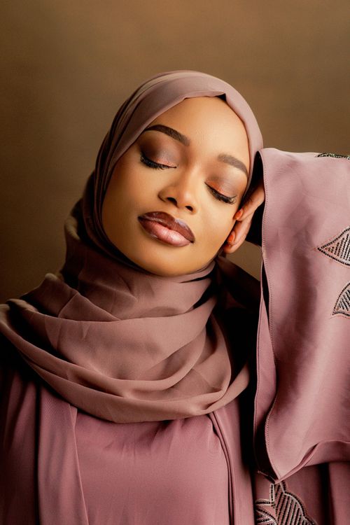 Free Serene woman in a mauve hijab with eyes closed, exuding elegance and peace. Stock Photo
