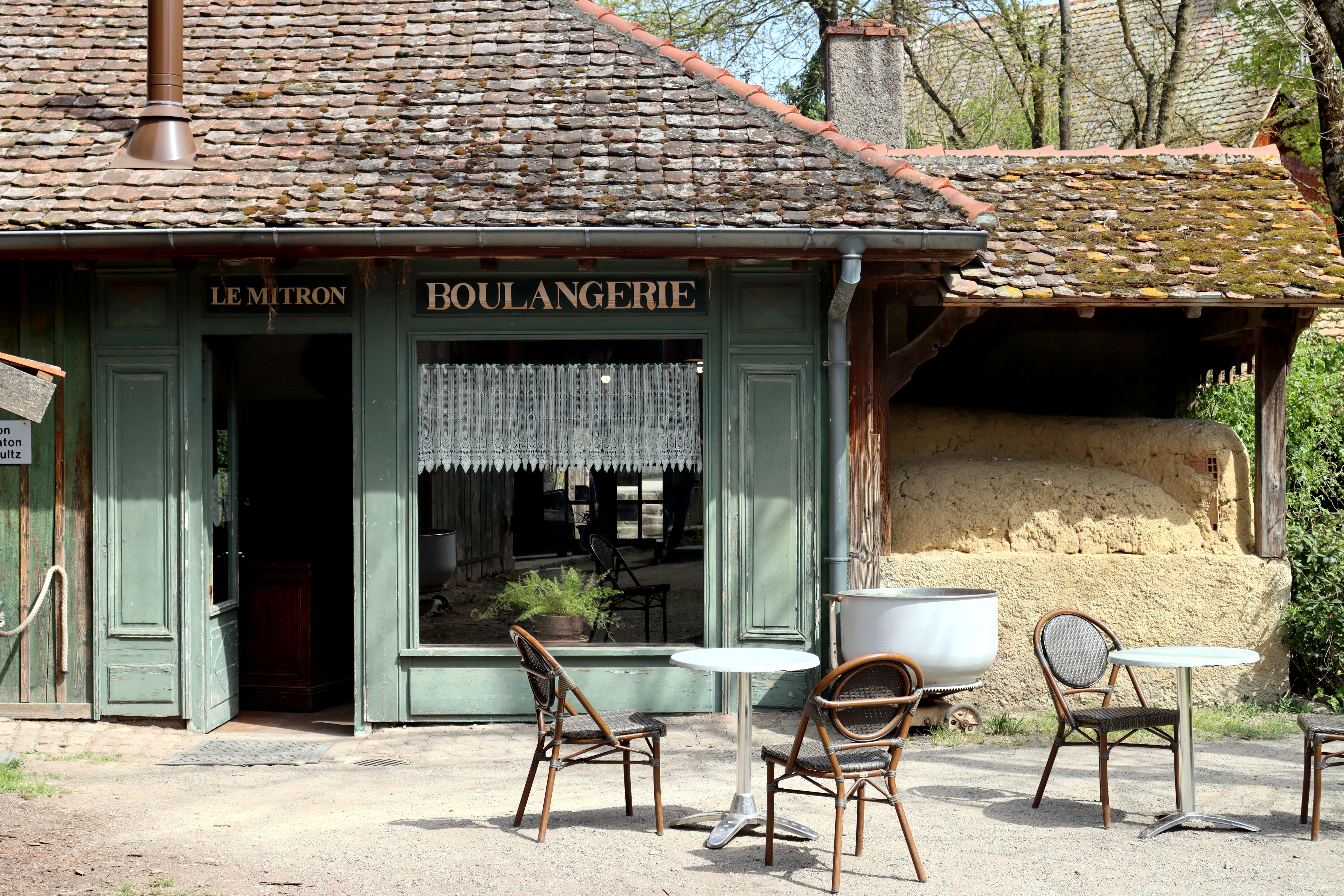 A quaint French boulangerie with rustic charm, showcasing outdoor seating in Ungersheim, Grand Est.