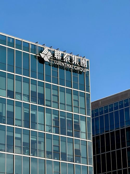 Free Glass facade of Luenthai Group office building in Shanghai with clear blue sky backdrop. Stock Photo