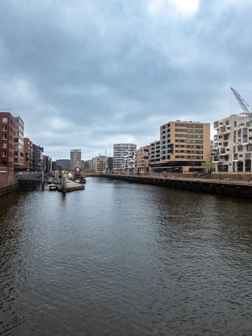 Free Contemporary urban skyline with waterfront modern buildings under a cloudy sky. Stock Photo