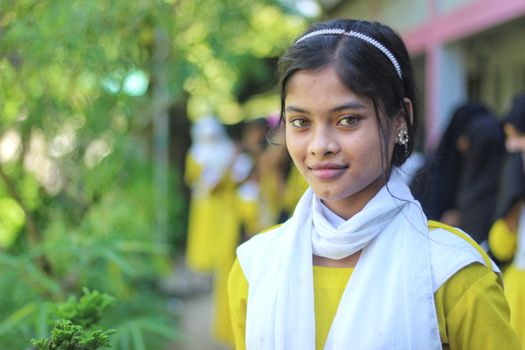 Smiling young woman in traditional attire captured outdoors in Bangladesh.