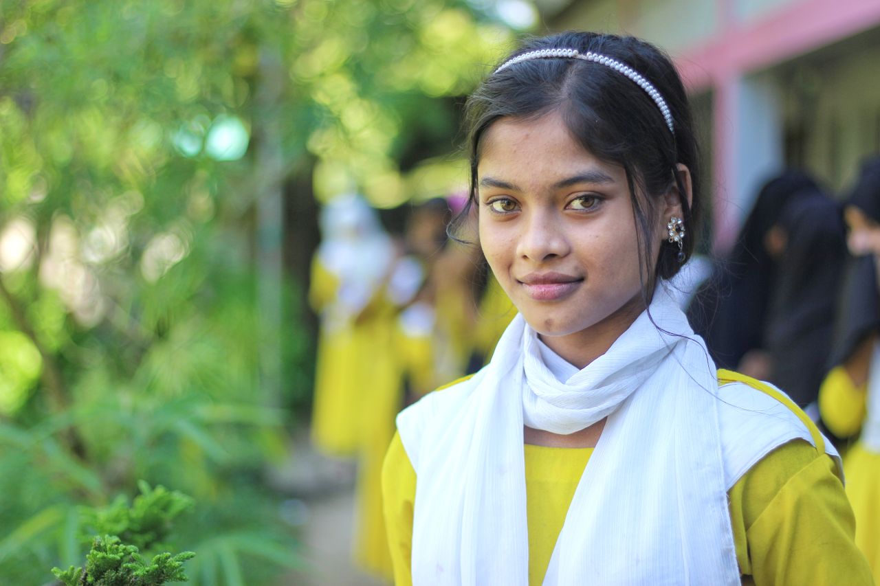 smiling young woman in traditional attire captured outdoors in banglad