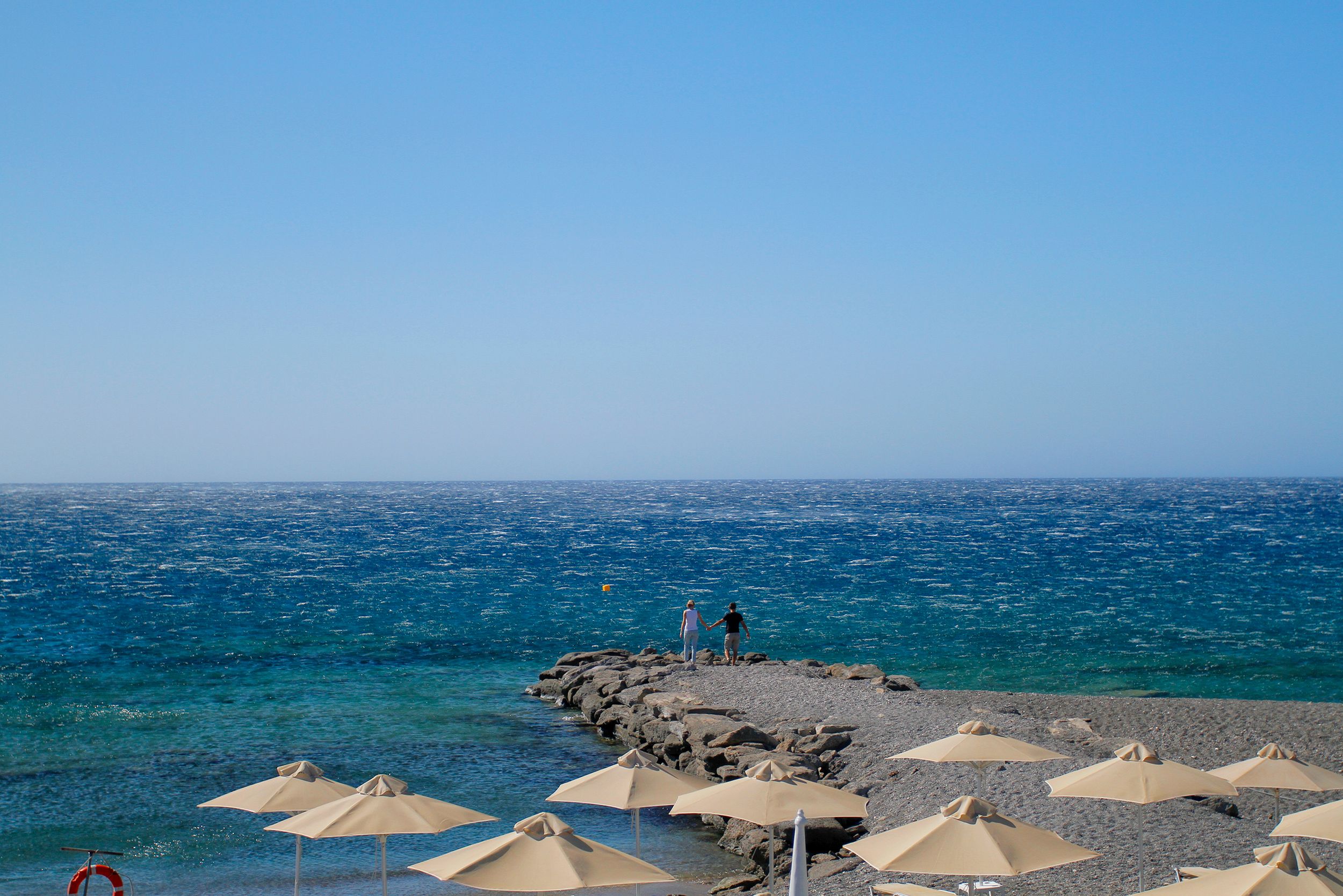 Peaceful beach scene with umbrellas and ocean view under a clear blue sky. - Photo by Сокіл Sokil on Pexels