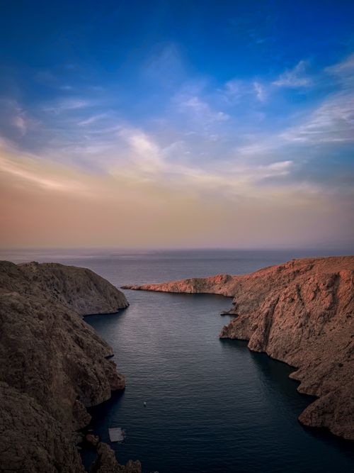 Free Stunning view of rugged coastal cliffs and the sea during sunset. Stock Photo
