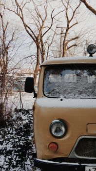 一辆经典的古董车停在户外，被雪覆盖，呈现出一幅冬日景象