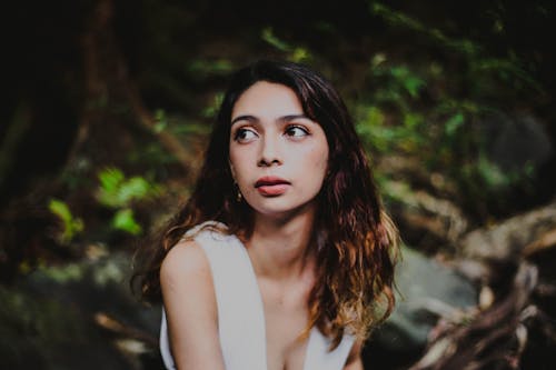 Portrait Photo of Woman in White Tank Top Looking Away