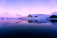 暮光之下，山景与湖泊的倒影捕捉了宁静，呈现出令人惊叹的冬季景观