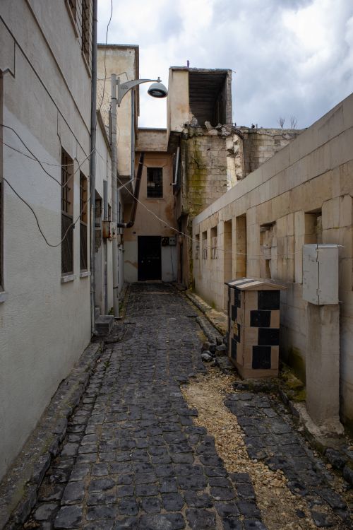 Free A narrow cobblestone alleyway in Gaziantep, showcasing historic architecture and moody weather. Stock Photo
