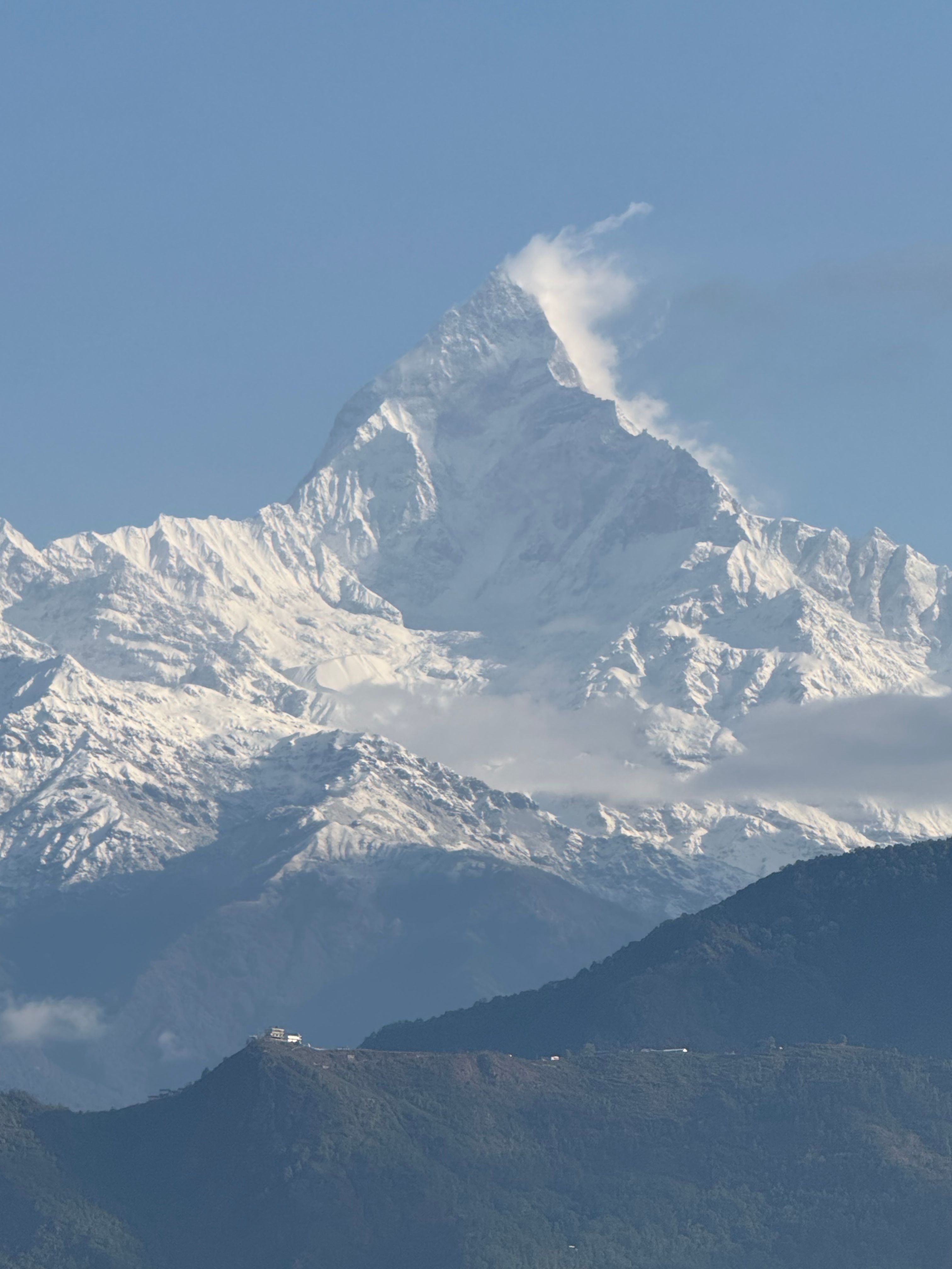 Idyllic scene of the snow-capped Machapuchare mountain in Nepal under a clear blue sky.