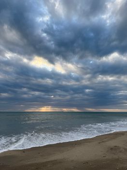 Capture of a serene sunrise over the calm ocean at Jensen Beach, Florida, with dramatic clouds.