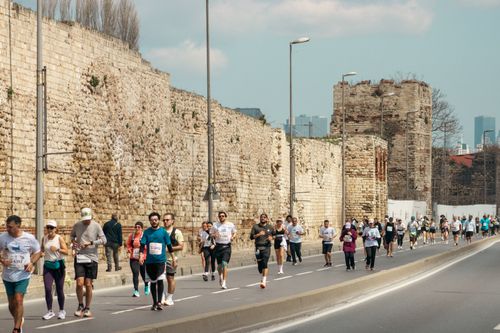 Free A dynamic scene of marathon runners beside ancient walls in Istanbul, Turkey. Stock Photo