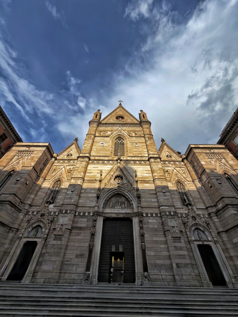 Facade of Naples Cathedral under a dramatic sky