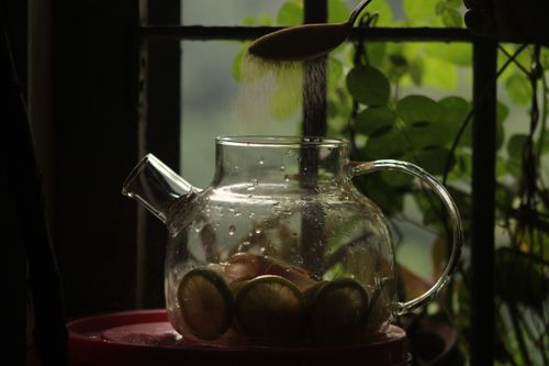 Free Glass teapot with lemon slices and sugar in soft window light, creating a cozy atmosphere. Stock Photo