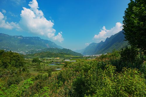 Free Beautiful valley landscape with lush green mountains and clear blue sky on a sunny day. Stock Photo