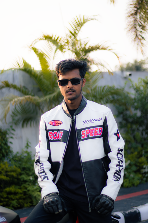 Free Young man wearing sunglasses and motorcycle jacket posing outdoors. Stock Photo