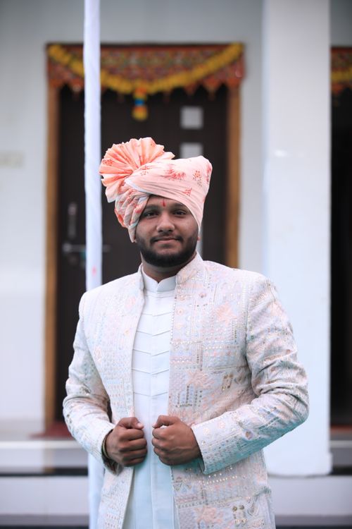 Free A groom stands confidently in traditional Indian wedding attire with a colorful turban, showcasing cultural elegance. Stock Photo