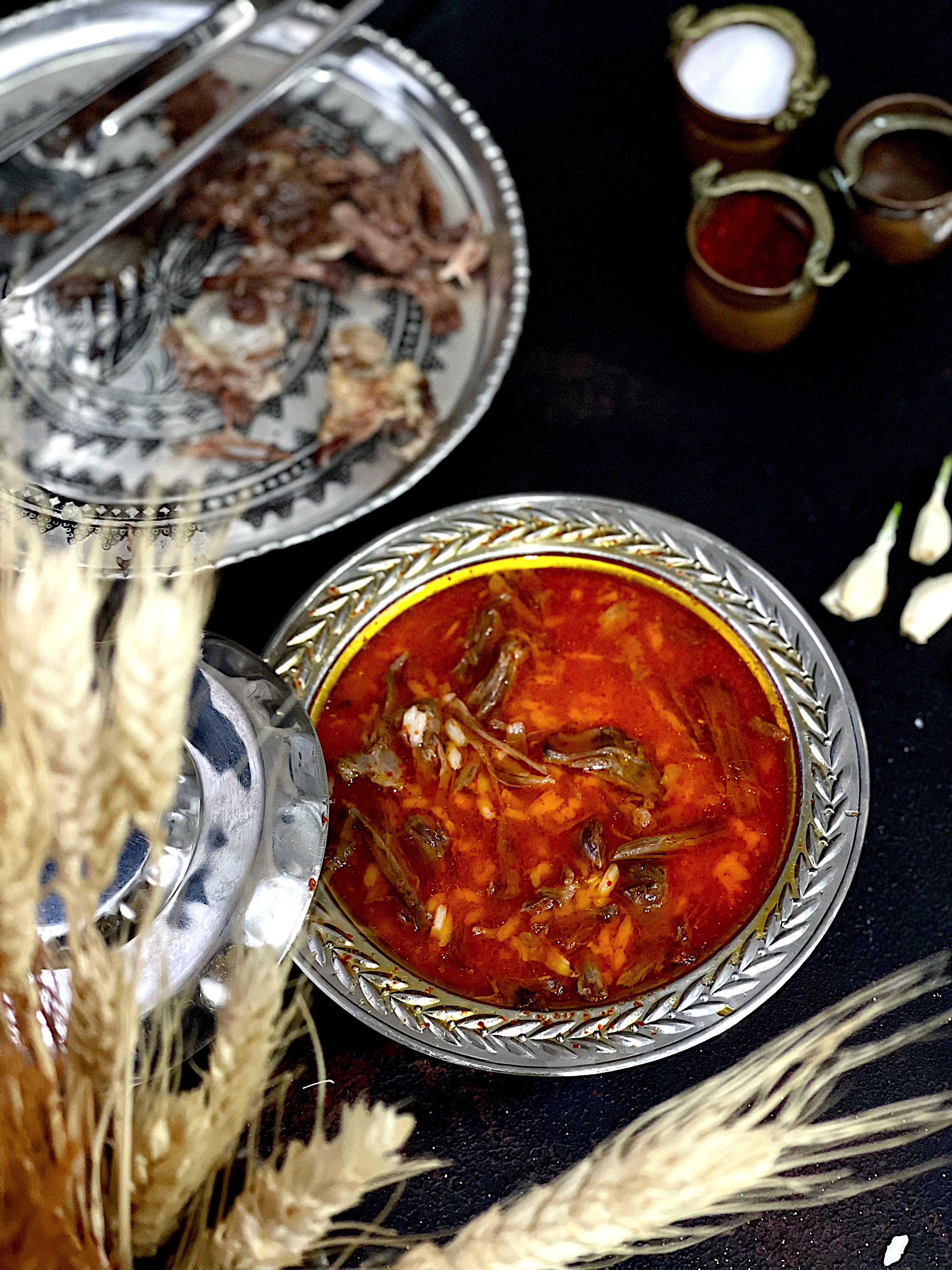 Delicious Turkish lamb stew in ornate dish, surrounded by spices, representing authentic cuisine.