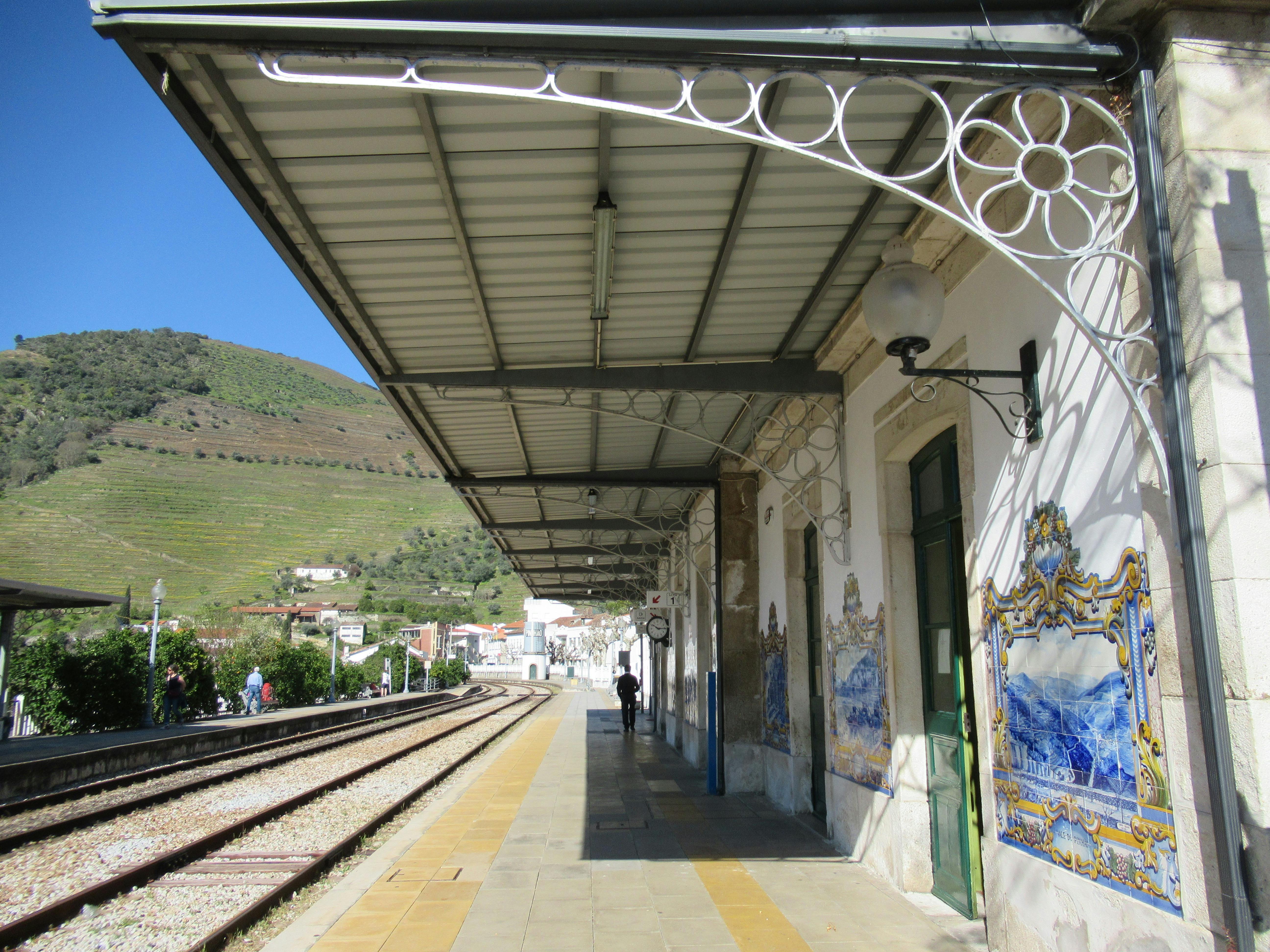 A train station in Portugal showcasing iconic azulejos and scenic hills.