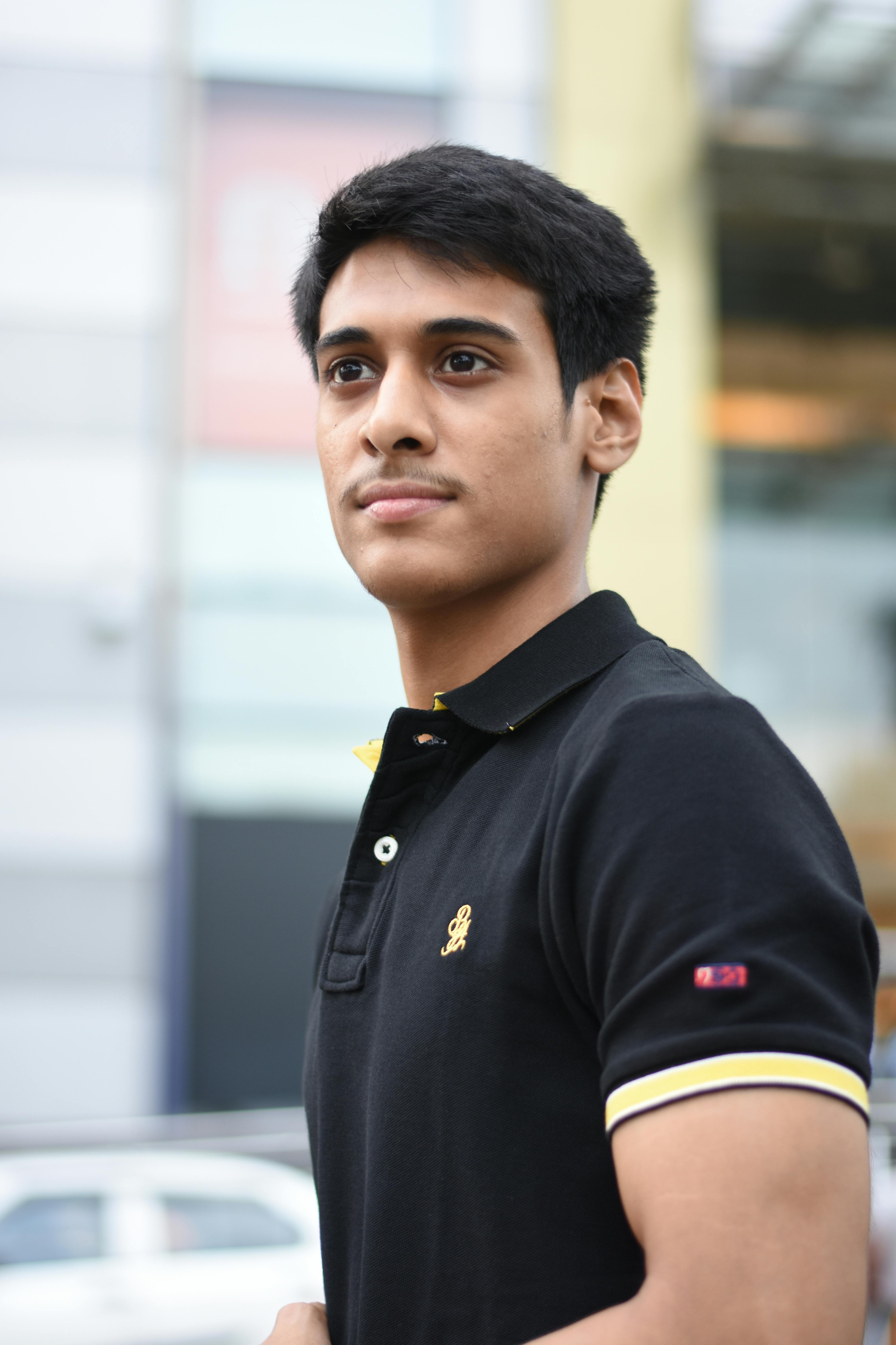 Casual portrait of a young man wearing a black polo shirt standing outdoors in Kolkata, India.