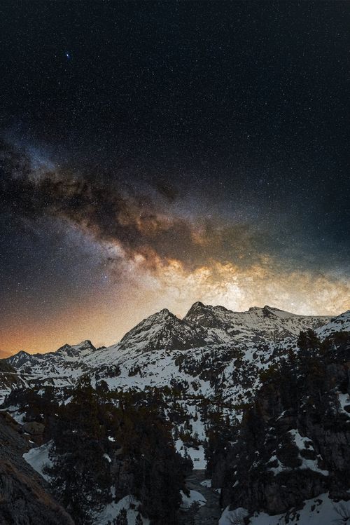 Free Breathtaking view of the Milky Way galaxy illuminating snowy mountains at night. Stock Photo