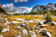 山间湖泊宁静的风景，周围环绕着郁郁葱葱的绿色植物和岩石地形