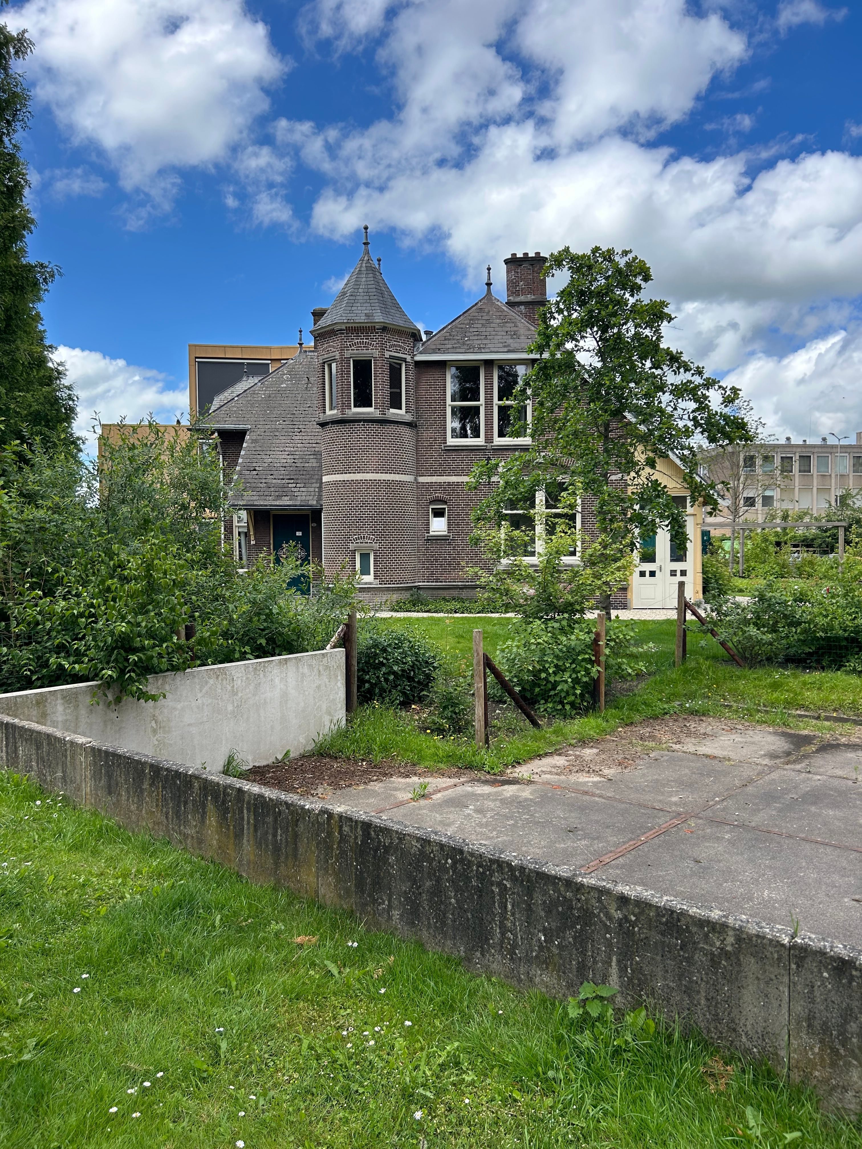 Charmant historisch huis, omgeven door groen in Groningen, Nederland, onder een stralend blauwe hemel.