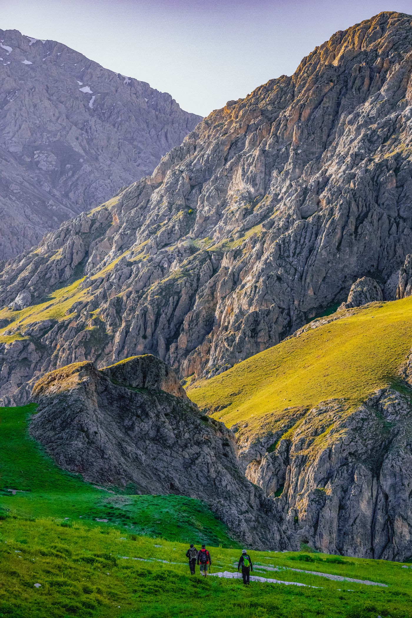 Hikers exploring a dramatic green mountain landscape