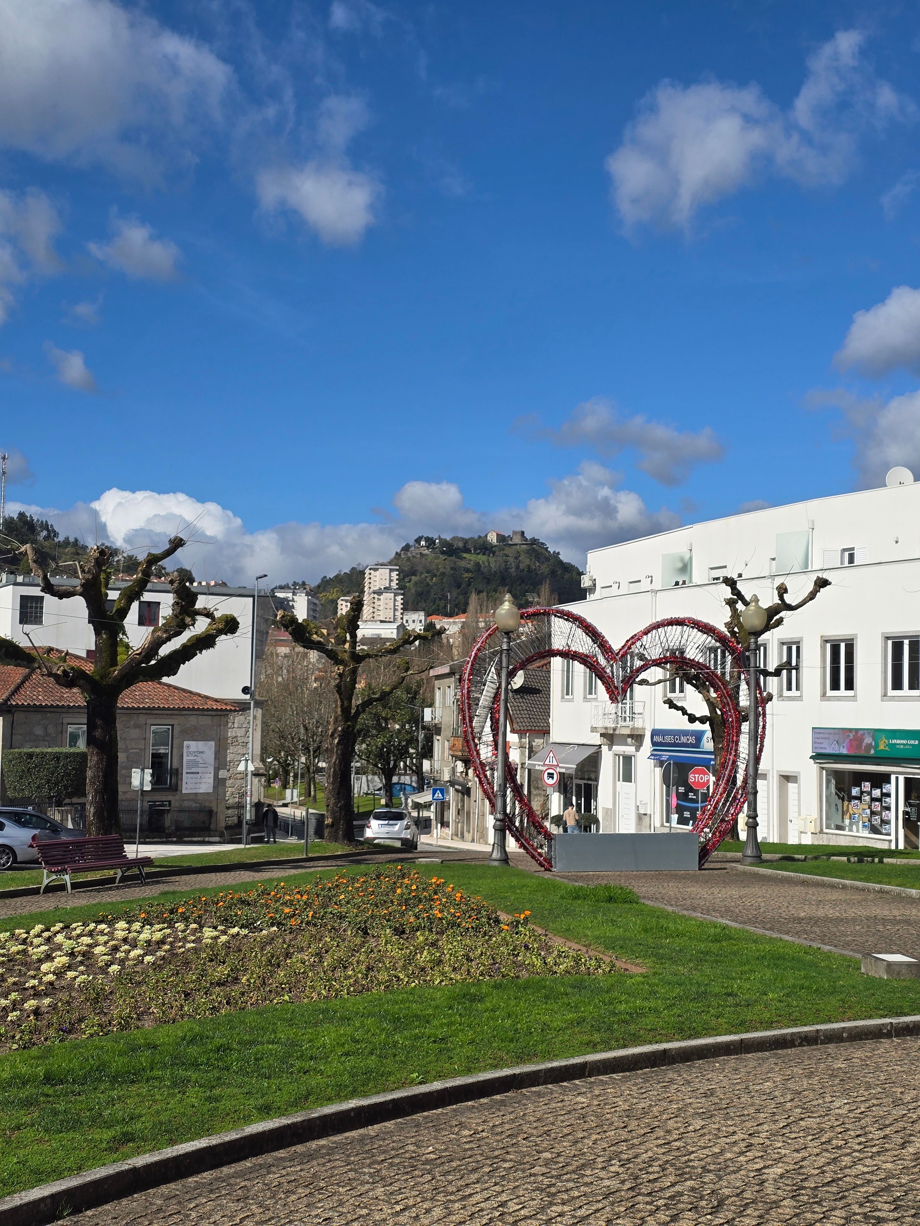 Picturesque European town with heart sculpture, architecture, and blue sky.