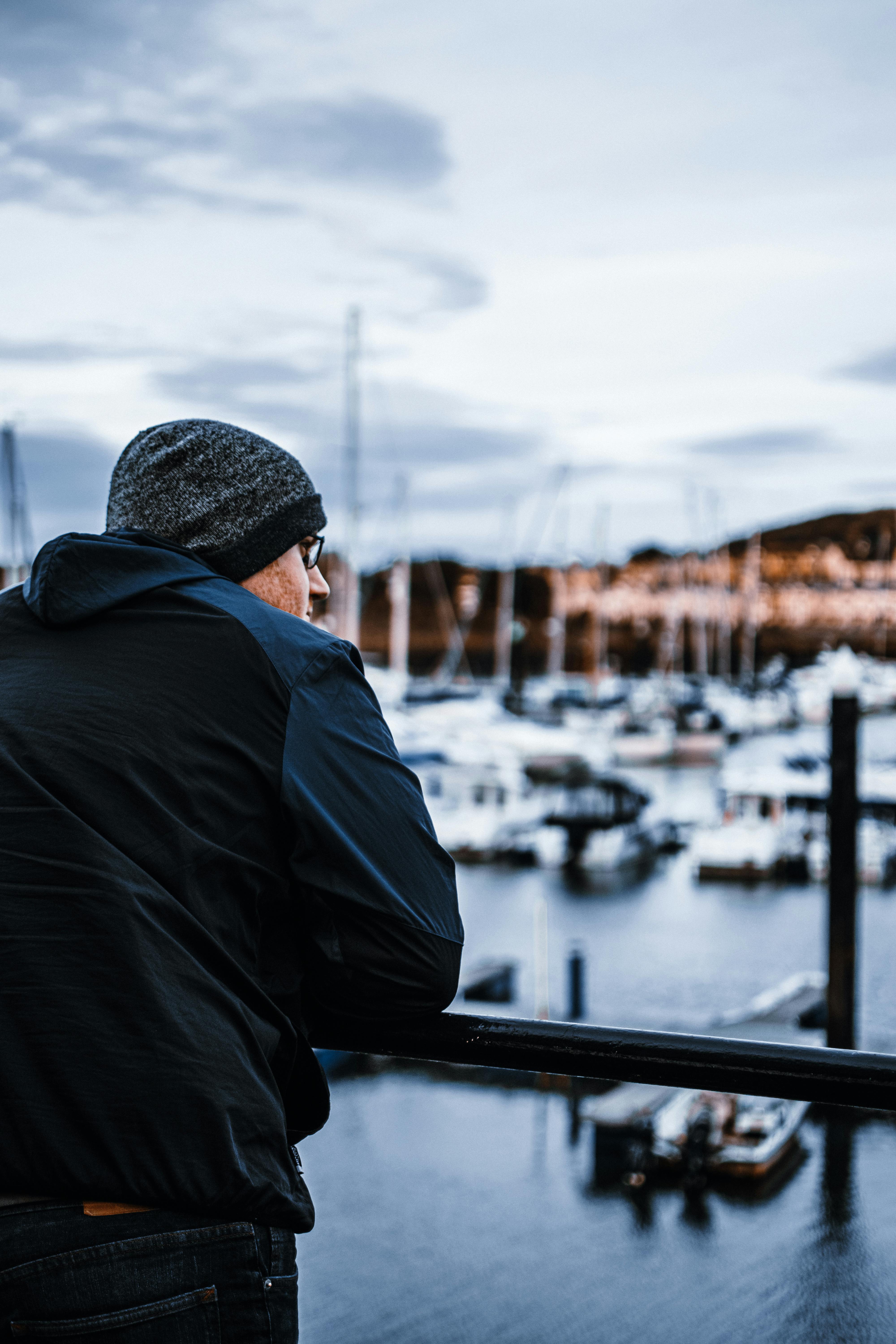 A man gazes over the scenic Conwy Marina in Wales, capturing a peaceful moment.