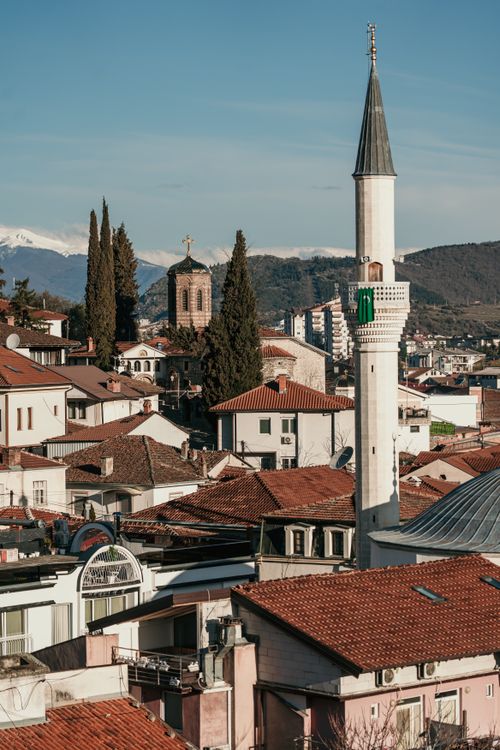 Free Rooftop view of Skopje featuring a prominent minaret and historical architecture with mountainous backdrop. Stock Photo