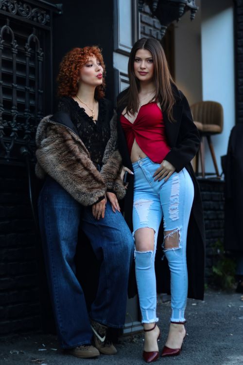 Free Two stylish young women pose confidently on an urban street, showcasing modern fashion with flair. Stock Photo