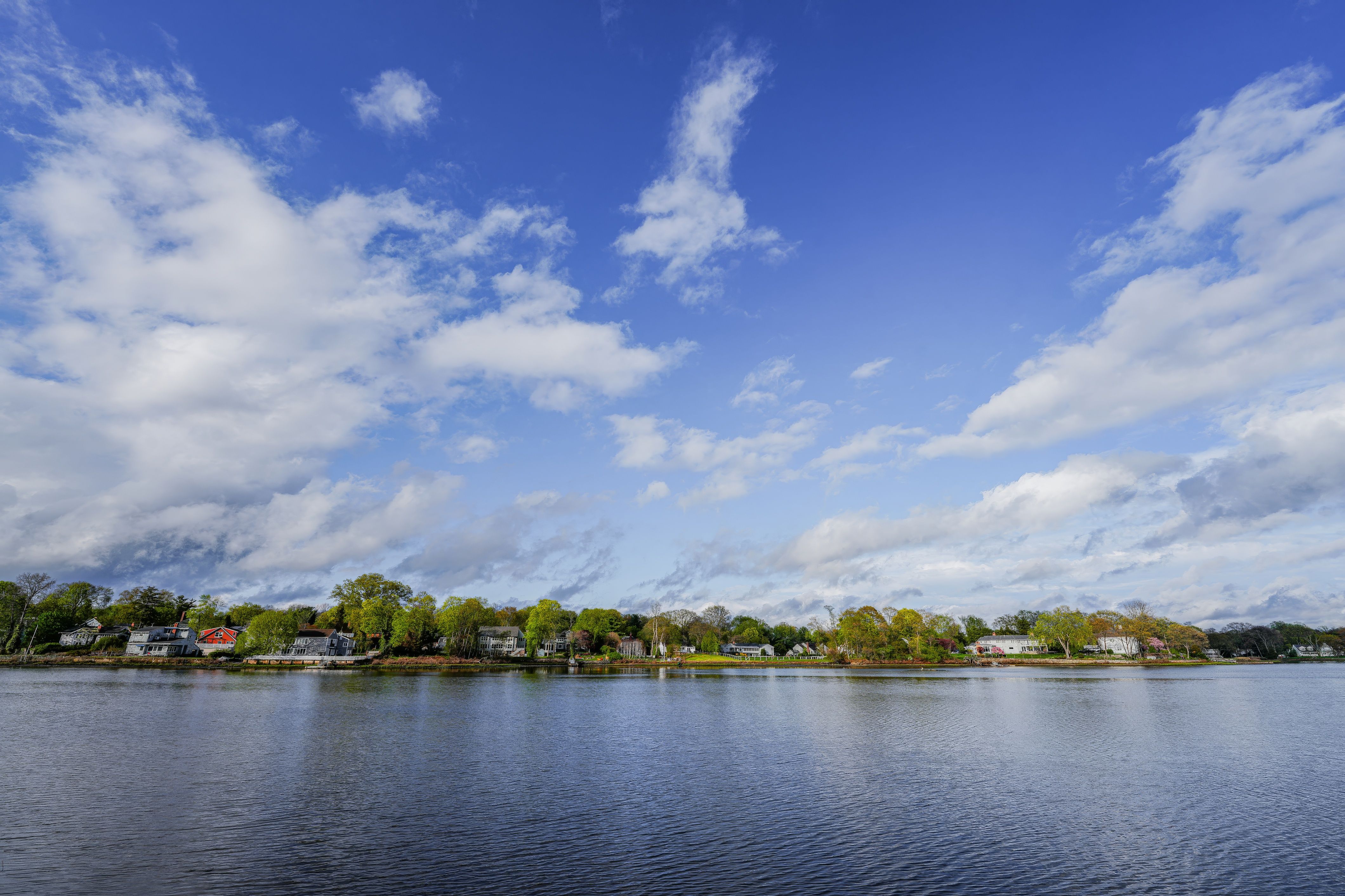 Peaceful waterfront scene with clear sky and homes in Stamford, Connecticut.