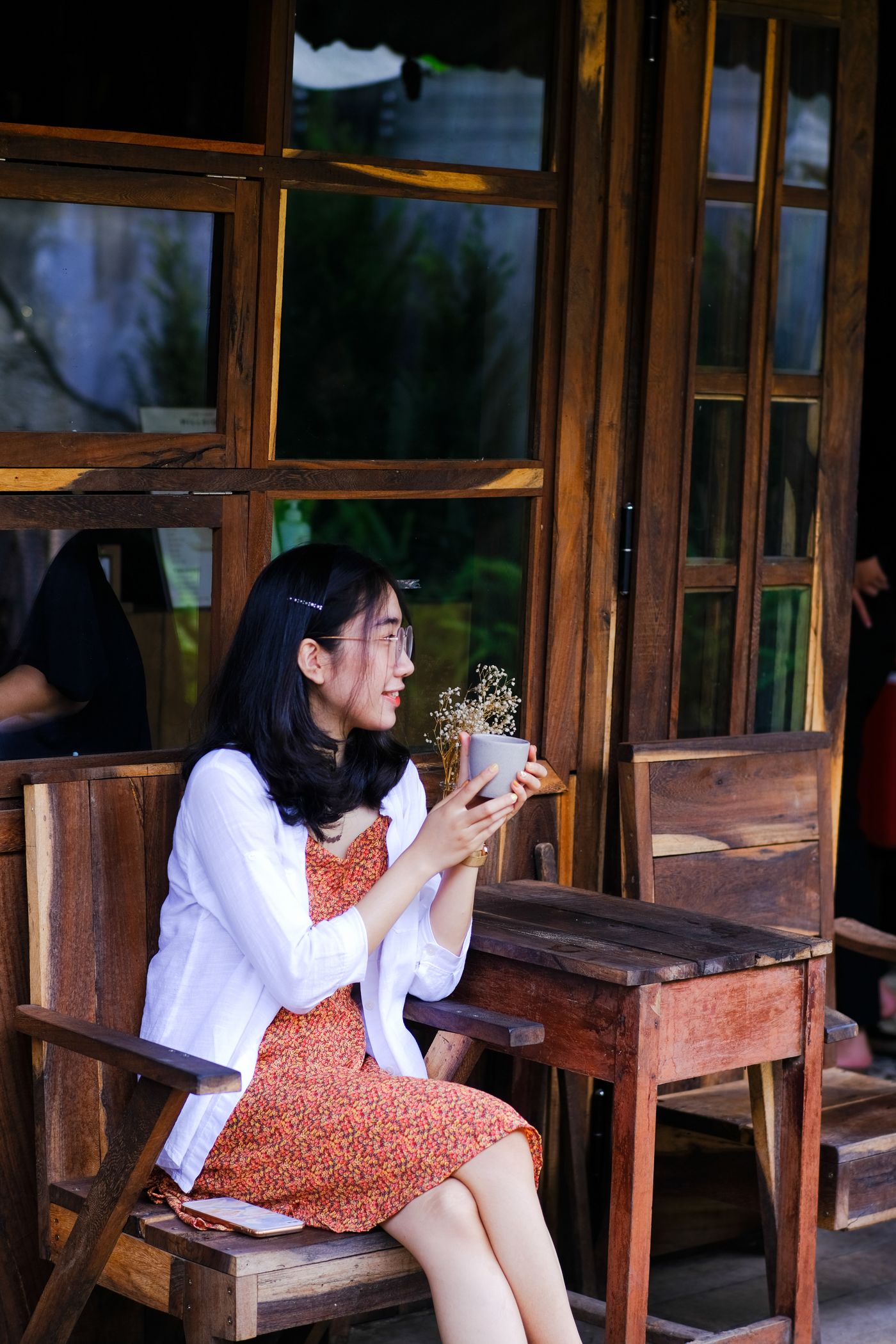 Người phụ nữ Việt cầm tách cà phê tại quán ở Huế